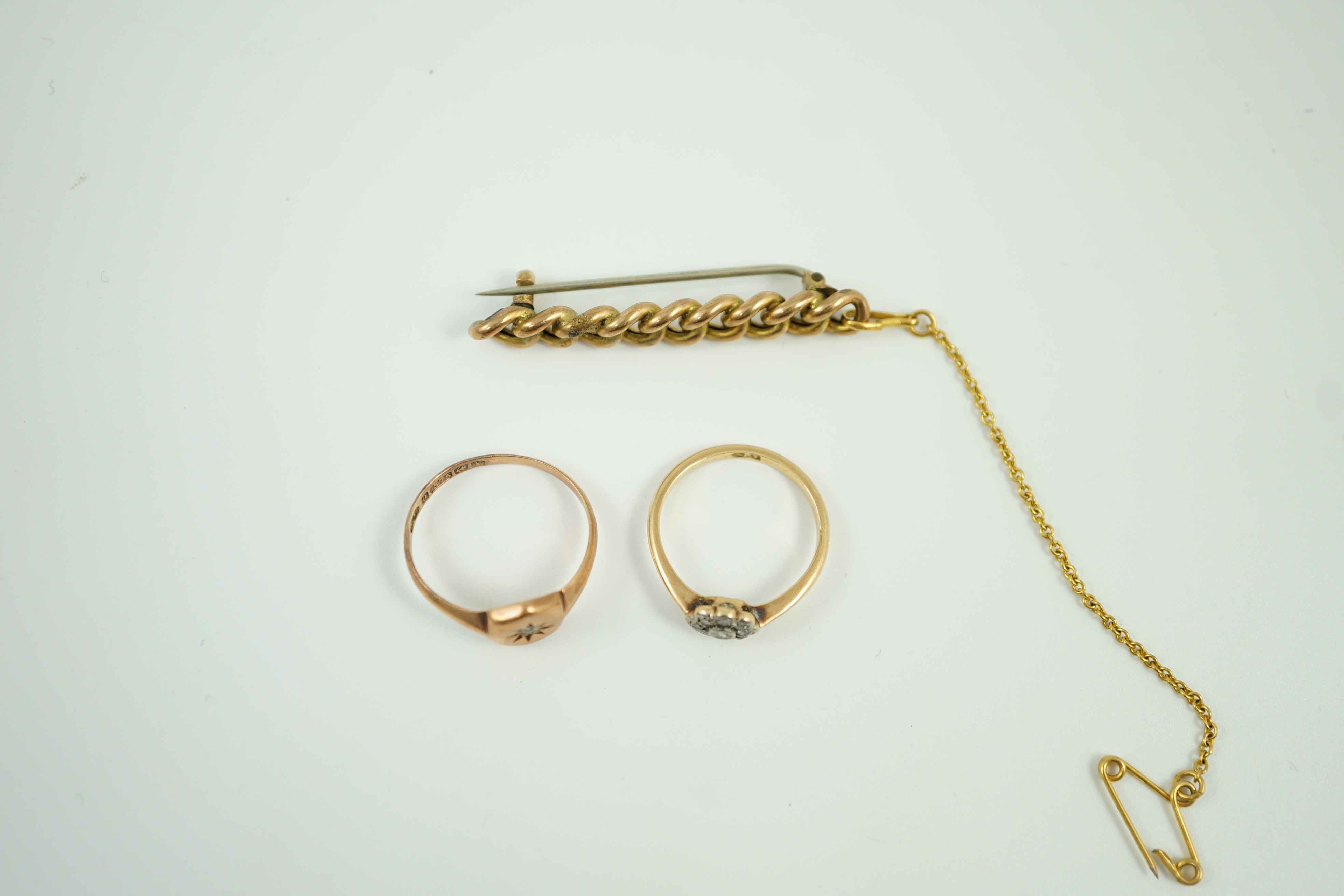 A small 18ct and diamond set cluster ring, size K, gross 1.2 grams, a 9ct gold and diamond chip set ring and a yellow metal curb link bar brooch, gross 5.1 grams.